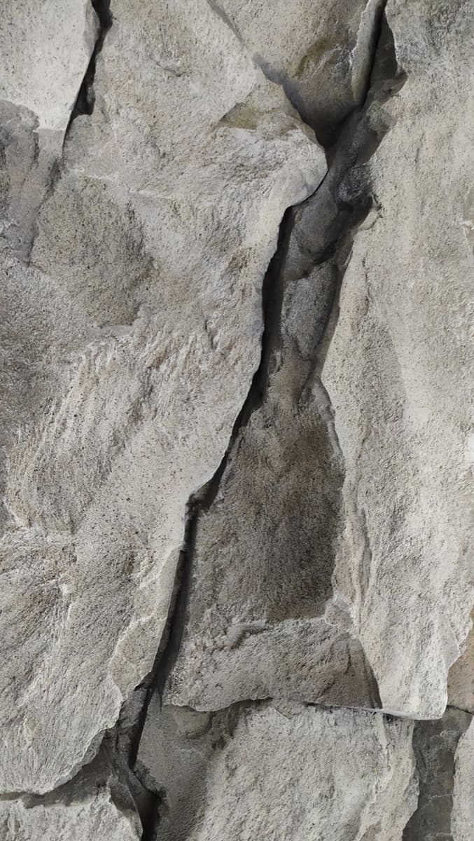 Naturstein i grå toner — grunnmurens materiale.